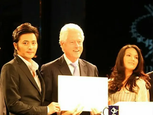 WFP広報大使を発表したクリントン前大統領と並ぶチャンさん（左端）＝3日、香港（聯合）