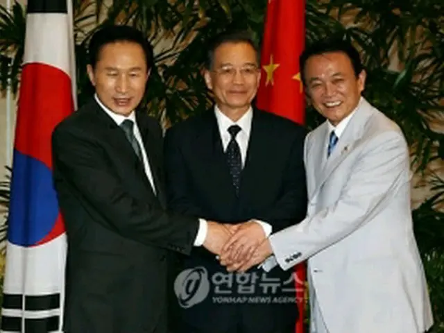 会談に先立ち記念撮影する韓中日首脳。左から李明博大統領、温家宝首相、麻生太郎首相＝１１日、パタヤ（聯合ニュース）