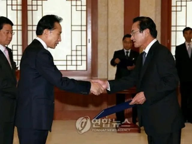 新閣僚に任命状を授与する李大統領（左）＝30日、ソウル（聯合ニュース）