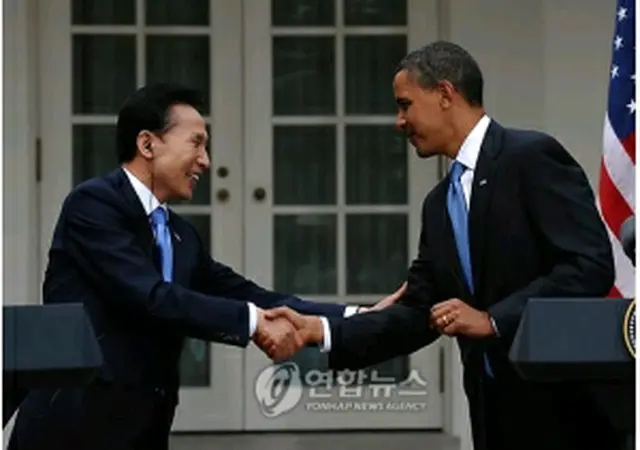 ６月の韓米首脳会談後、記者会見で握手を交わす李明博大統領（左）とオバマ大統領＝（聯合ニュース）