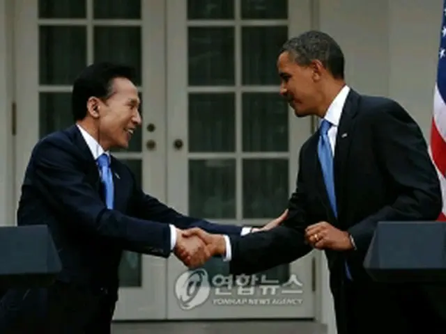 ６月の韓米首脳会談後、記者会見で握手を交わす李明博大統領（左）とオバマ大統領＝（聯合ニュース）