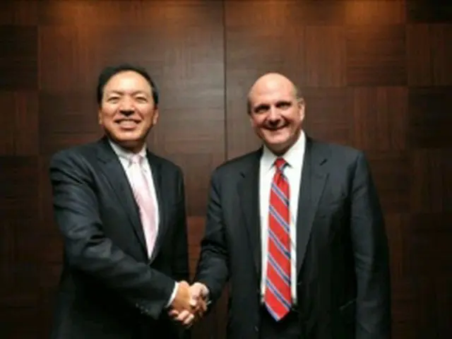 握手を交わす李潤雨副会長（左）とバルマーCEO＝2日、ソウル（聯合ニュース）