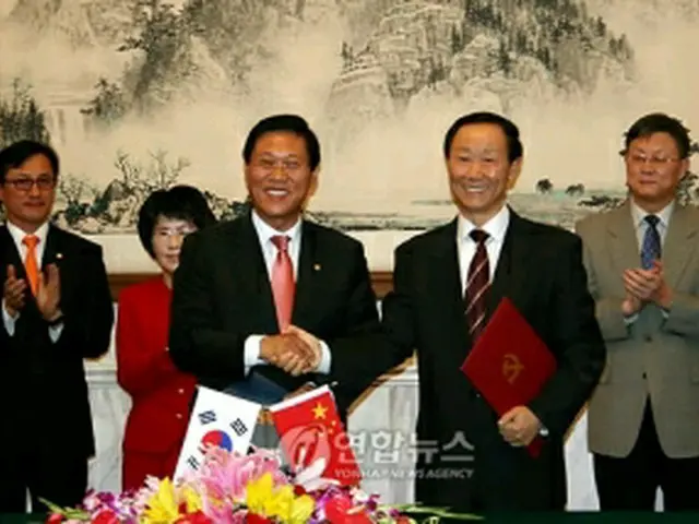 MOU締結後、握手を交わす張事務総長（左）と王部長＝3日、北京（聯合ニュース）