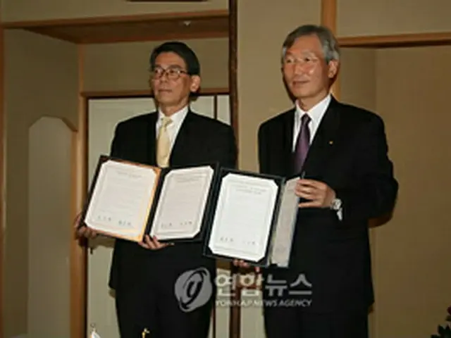 協定書調印式を行う韓国側の李京勲会長（右）と日本側の森本広会長＝（聯合ニュース）