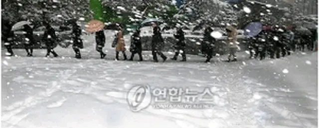 大雪の中で通勤する市民ら＝4日、ソウル（聯合ニュース）