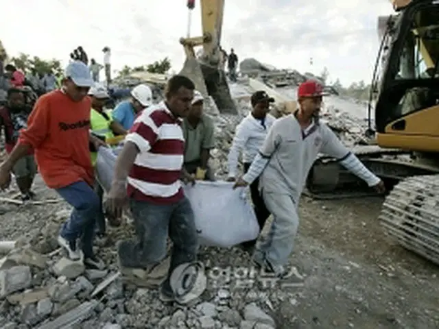 犠牲者の遺体を運ぶボランティア＝14日、ハイチ（EPA＝聯合ニュース）