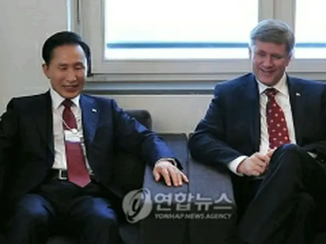 カナダのハーパー首相（右）と会談する李明博大統領＝28日、ダボス（聯合ニュース）