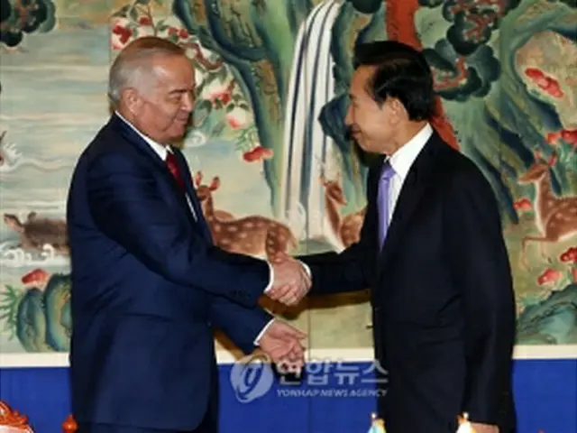握手を交わすカリモフ大統領（左）と李明博大統領＝11日、ソウル（聯合ニュース）
