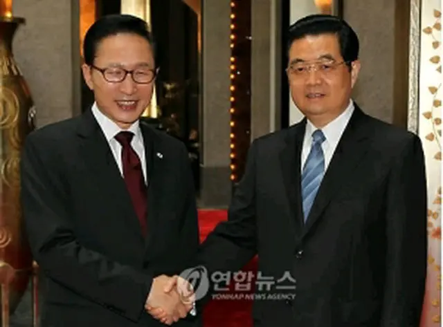 会談に先立ち握手を交わす韓中首脳＝30日、上海（聯合ニュース）