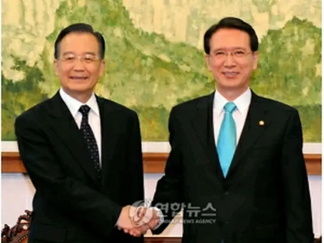 握手を交わす温首相（左）と金国会議長＝28日、ソウル（聯合ニュース）