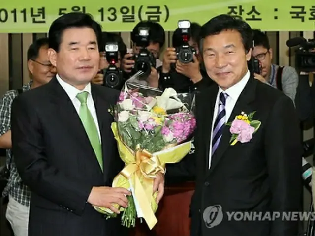 民主党の院内代表に選出された金振杓氏（左）。右は同党の孫鶴圭代表＝１３日、ソウル（聯合ニュース）