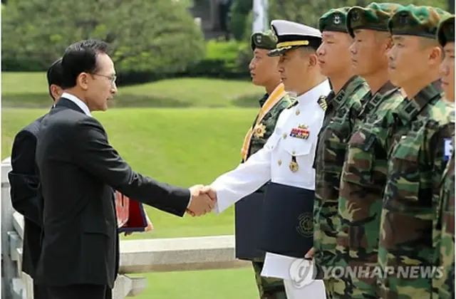 李大統領（左）から勲章を渡される清海部隊の隊員ら＝３０日、ソウル（聯合ニュース）