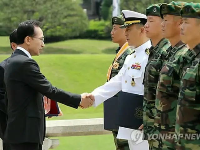 李大統領（左）から勲章を渡される清海部隊の隊員ら＝３０日、ソウル（聯合ニュース）