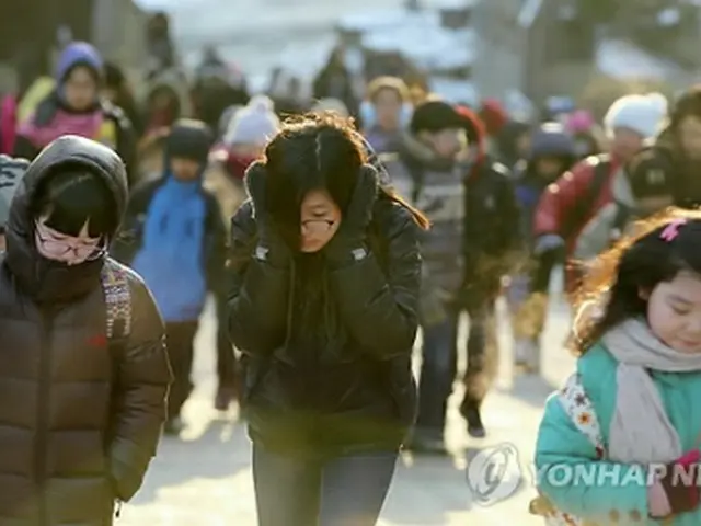 ソウルでは2日朝の最低気温が氷点下17度を記録した。厚手のジャンパーを着込んで登校する市内の小学生ら＝2日、ソウル（聯合ニュース）