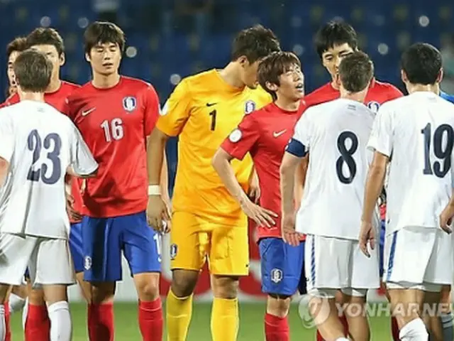 試合後、ウズベキスタンの選手と握手する赤いユニフォームの韓国選手＝11日、タシケント（聯合ニュース）