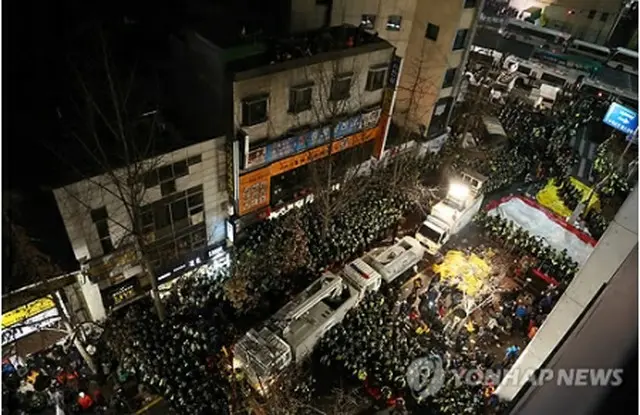 ２２日午後、警察が突入した民主労総本部の周辺の様子。労組組合員や警察の強行突入に抗議する市民団体関係者らで混雑している＝２２日、ソウル（聯合ニュース）