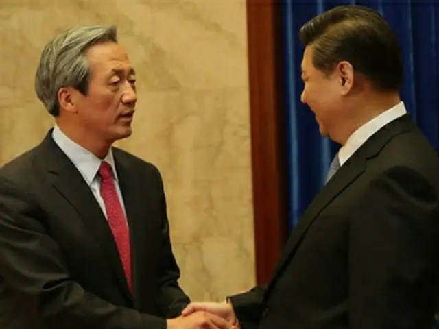 鄭夢準議員（左）と握手を交わす習近平国家主席＝21日、北京（聯合ニュース）
