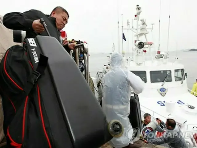 港で事故海域に向かう準備をしている民間団体のダイバーら＝１７日、珍島（聯合ニュース）