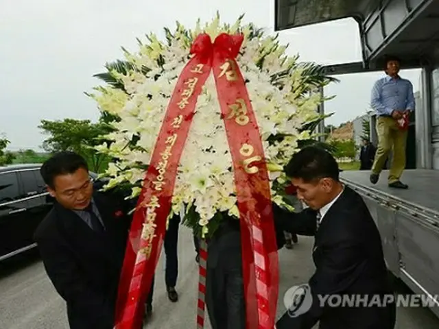 花輪を運ぶ北朝鮮側関係者（写真共同取材団）＝17日、開城（聯合ニュース）