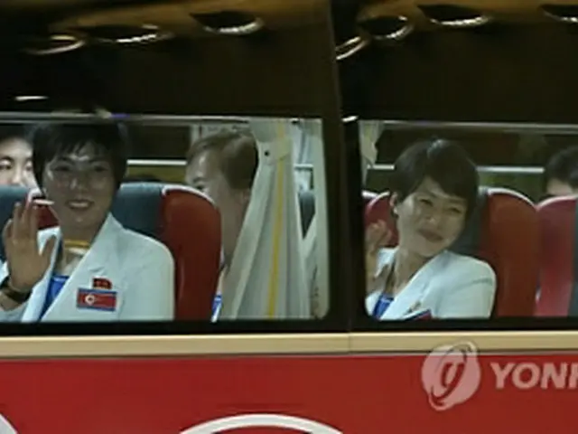 選手村に向かうバスの中で手を振る北朝鮮の選手ら＝11日、仁川（聯合ニュース）