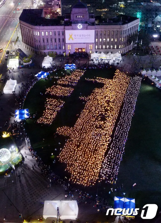 韓国・ソウル市庁前のソウル広場で開かれたセウォル号事故1年を祈る4160個のロウソクでセウォル号を作る行事が行われた。（提供:news1）