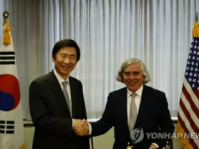 原子力協定に正式署名してから握手を交わす尹長官（左）とモニズ長官＝（聯合ニュース）
