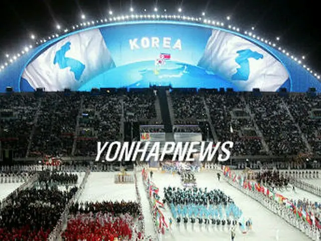 開幕式で合同入場する南北選手団。朝鮮半島旗とKOREAの文字が映し出されている＝1日、ドーハ（聯合）
