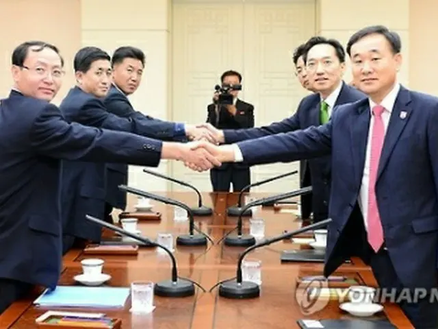 協議で握手を交わす韓国代表(右)と北朝鮮代表(統一部提供)=7日、ソウル(聯合ニュース)