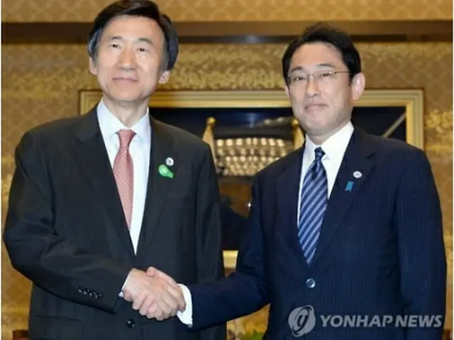 ６月に東京で行った会談で握手を交わす韓日外相＝（聯合ニュース）