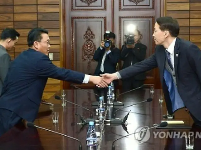 実務協議で握手を交わす韓国統一部の金基雄（キム・ギウン）南北会談本部長（右）と北朝鮮・祖国平和統一委員会のファン・チョル書記局部長（統一部提供）＝２６日、ソウル（聯合ニュース）