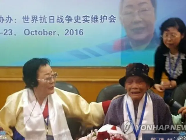 発言中、涙を流す中国人慰安婦被害者（右）を慰める韓国人被害者の李容洙（イ・ヨンス）さん