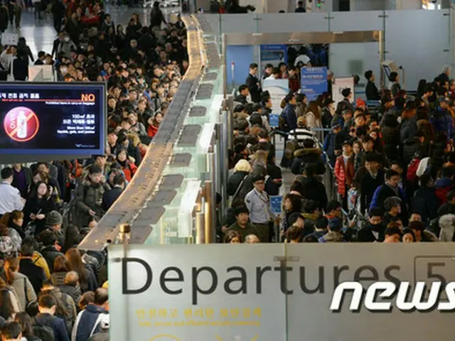 旧正月連休を控えた25日、多くの海外観光客が仁川国際空港で長い列を成し、出国審査を待機している。