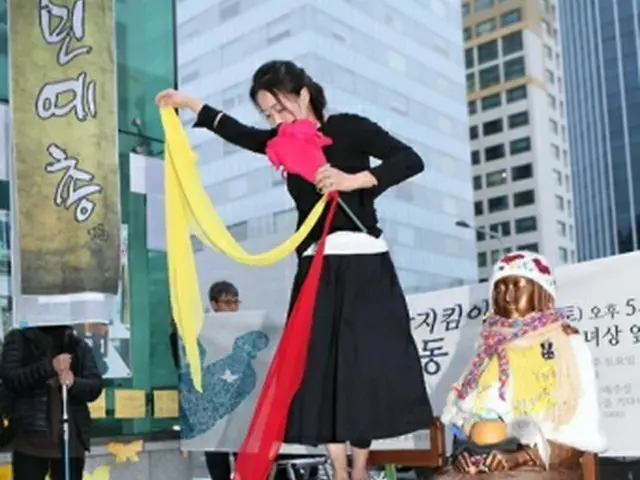 少女像のそばでパフォーマンスを行う舞踊家＝４日、釜山（聯合ニュース）