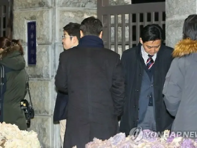 李容疑者の逮捕に表情を曇らせるサムスン関係者＝１７日、ソウル（聯合ニュース）