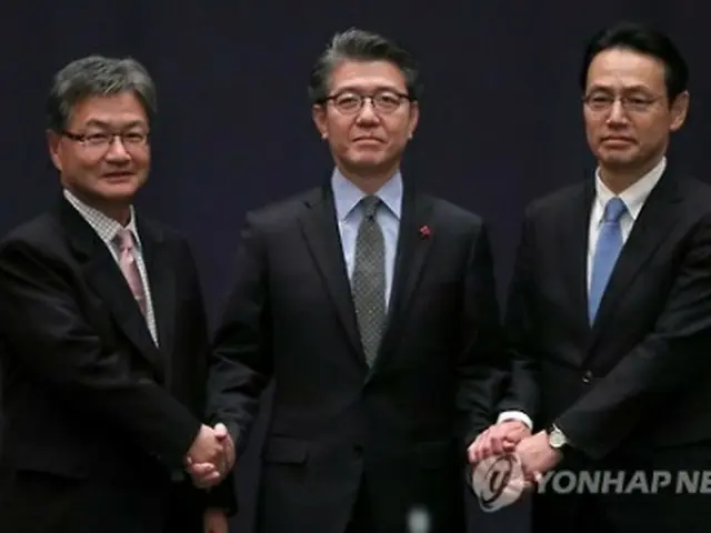 昨年１２月１３日、ソウルで開かれた３カ国首席代表会合で握手を交わす金本部長（中央）と金杉局長（右）＝（聯合ニュース）