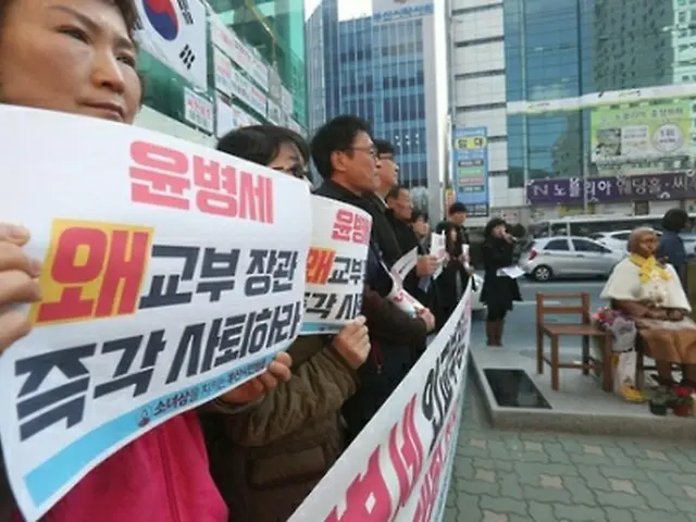 少女像の前で会見を行う市民団体＝２８日、釜山（聯合ニュース）
