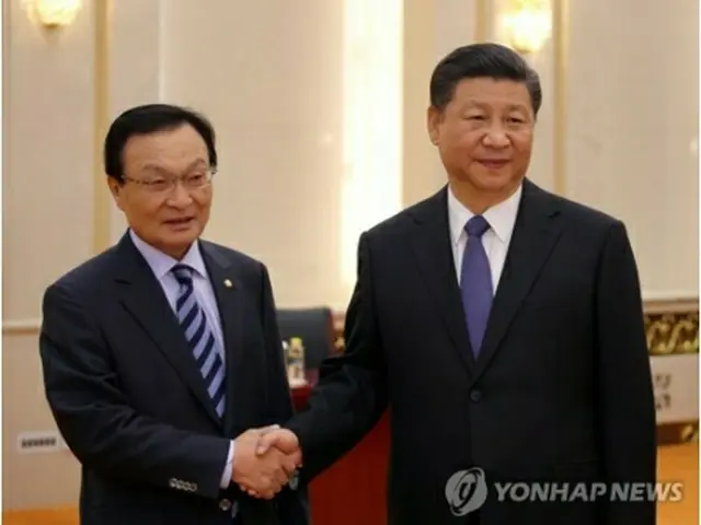 握手を交わす李海チャン氏（左）と習近平氏＝１９日、北京（聯合ニュース）