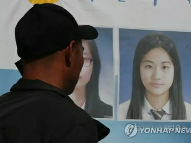 娘の写真を見つめるホ・ダユンさんの父親＝１９日、木浦（聯合ニュース）