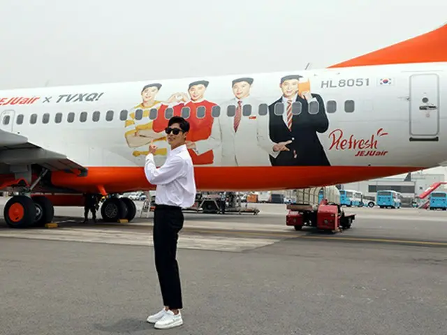 6月19日、「東方神起」ユンホがSMエンタテインメントの済州ワークショップに行く前、自分の顔がラッピングされたチェジュ航空のラッピング機を背景に写真撮影をしている。（オフィシャル）