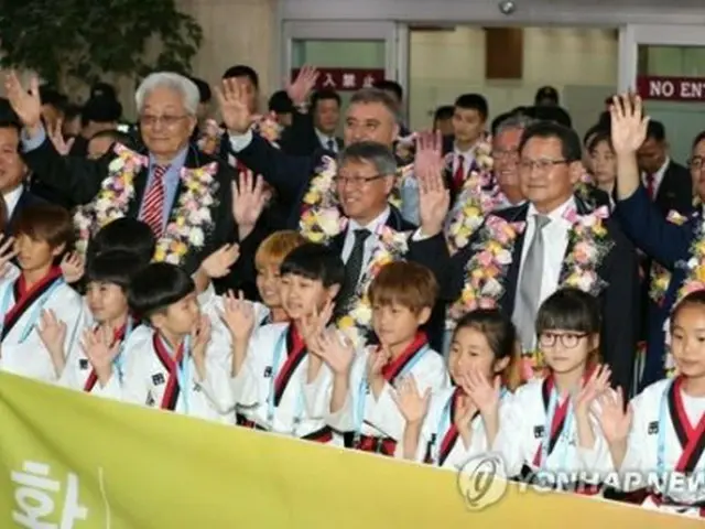 金浦空港でＷＴＦの子どもたちの歓迎を受ける張雄ＩＴＦ名誉総裁（２列目左から２人目）、李勇鮮ＩＴＦ総裁（同中央）ら＝２３日、ソウル（聯合ニュース）