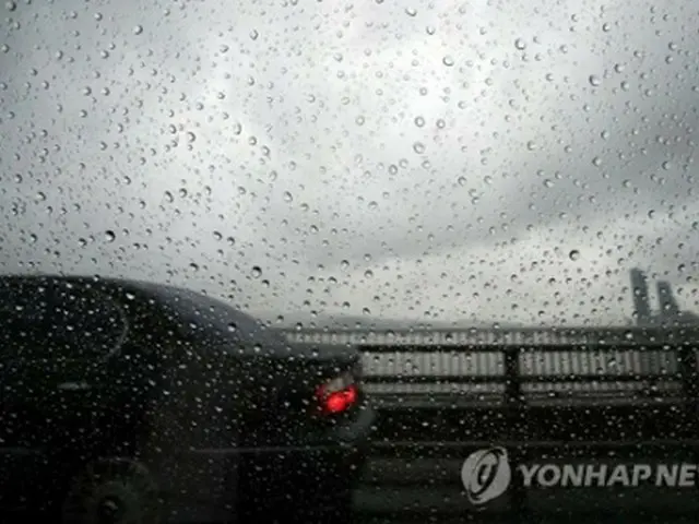 出勤時間帯のソウル。空は厚い雲に覆われ、雨が降っている＝１０日、ソウル（聯合ニュース）