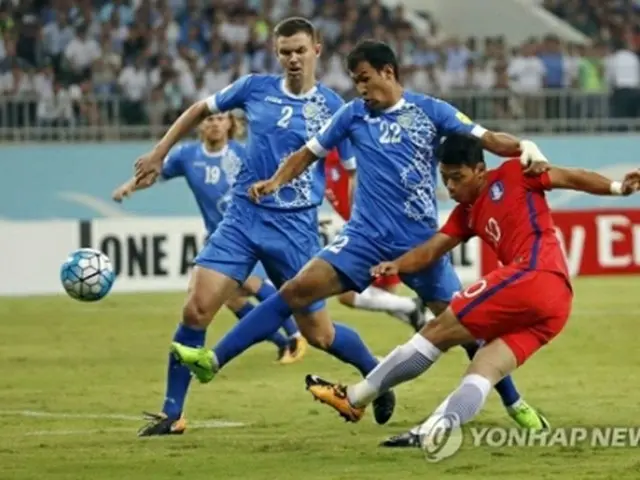 ウズベキスタンの選手と競り合う赤いユニホームの韓国代表=５日、タシケント(聯合ニュース)