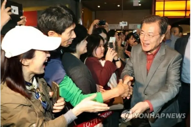 映画鑑賞後、市民と握手を交わす文大統領（右）＝１５日、釜山（聯合ニュース）