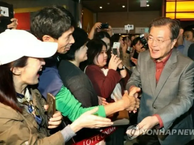 映画鑑賞後、市民と握手を交わす文大統領（右）＝１５日、釜山（聯合ニュース）