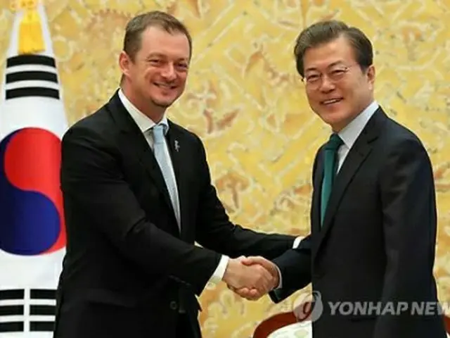 ＩＰＣのパーソンズ会長（左）と握手する文大統領＝１７日、ソウル（聯合ニュース）