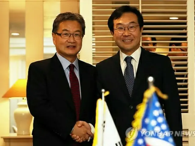 握手を交わす李本部長（右）とユン特別代表＝１７日、済州（聯合ニュース）