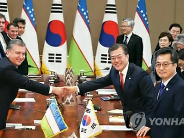 拡大首脳会談で握手する文大統領（右）とミルジヨエフ大統領＝２３日、ソウル（聯合ニュース）