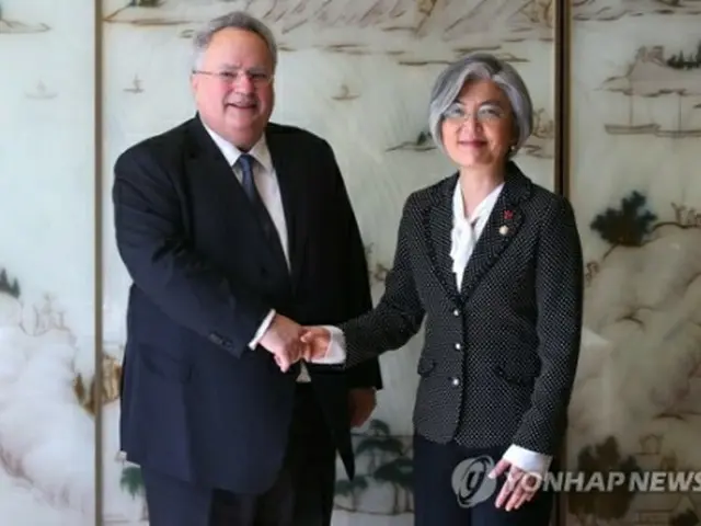 ソウル市内のホテルで行われた会談で握手を交わす康氏(右)とコジアス氏=30日、ソウル(聯合ニュース)