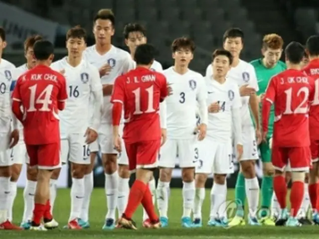 試合後、北朝鮮選手と握手を交わす白いユニフォームの韓国代表＝１２日、東京（聯合ニュース）