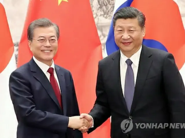 会談で握手を交わす文大統領（左）と習主席＝１４日、北京（聯合ニュース）